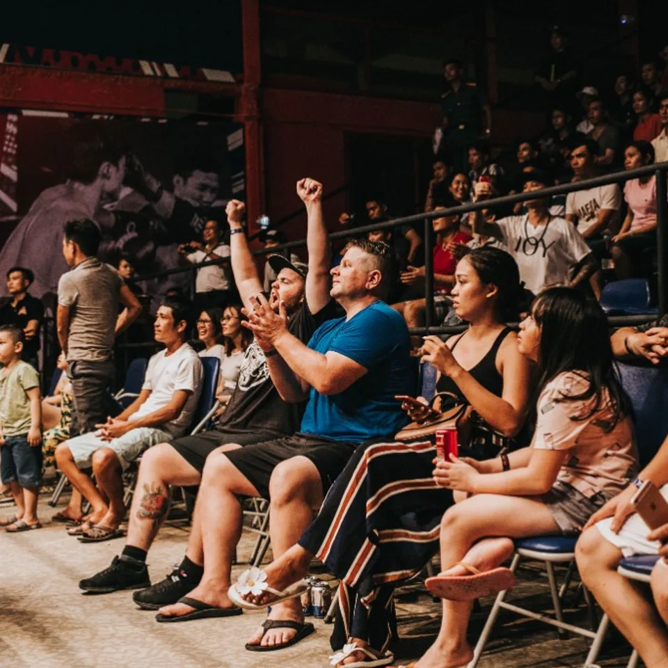 Ringside crowd cheering at a championship fight night